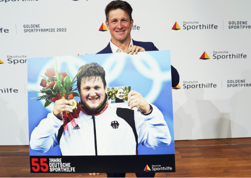 Ein Stück Sportgeschichte: Matthias Steiner signiert ein Bild seines Siegermoments bei Olympia 2008